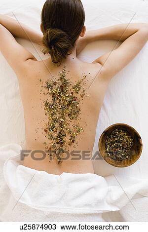 Stock Image - Woman's back with herbs. Fotosearch