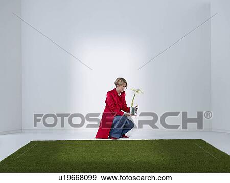 Stock Photo - Women looking at flower in green office. Fotosearch