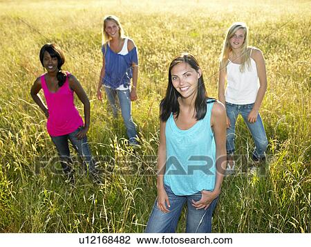 "Women standing in a field, smiling" View Large Photo Image Stock Image - "Women standing in a field, smiling". Fotosearch