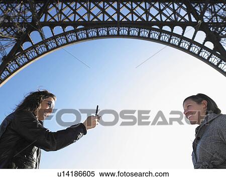 Women taking picture under Eiffel tower View Large Photo Image Stock Photography - Women taking picture under Eiffel tower. Fotosearch