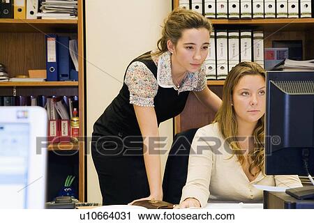 Stock Image - Women working together at computer. Fotosearch