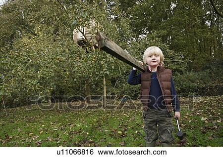 Young boy building treehouse View Large Photo Image Stock Photograph - Young boy building treehouse. Fotosearch