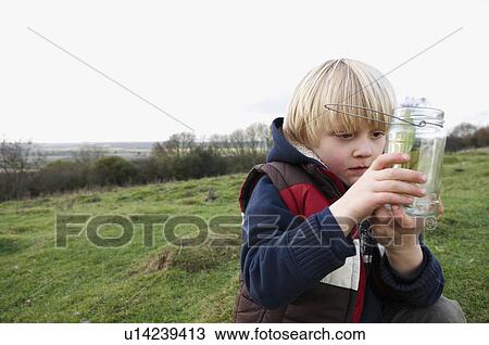Young boy inspecting jar of insects View Large Photo Image Stock Image - Young boy inspecting jar of insects. Fotosearch