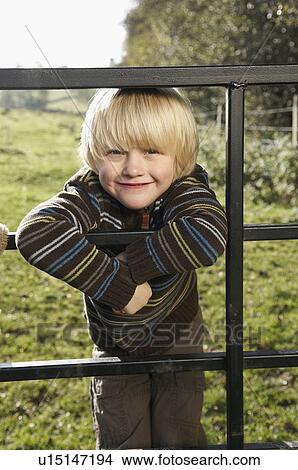 Young boy on gate in countryside View Large Photo Image Picture - Young boy on gate in countryside. Fotosearch
