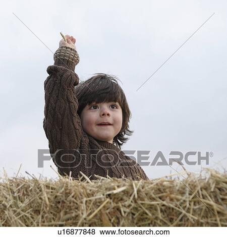Stock Photo - Young boy on hay bale. Fotosearch