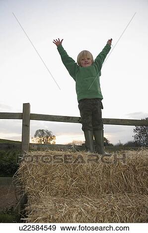 Young boy on hay bales View Large Photo Image Stock Photo - Young boy on hay bales. Fotosearch