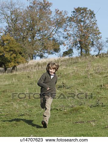 Young boy running in countryside View Large Photo Image Stock Image - Young boy running in countryside. Fotosearch