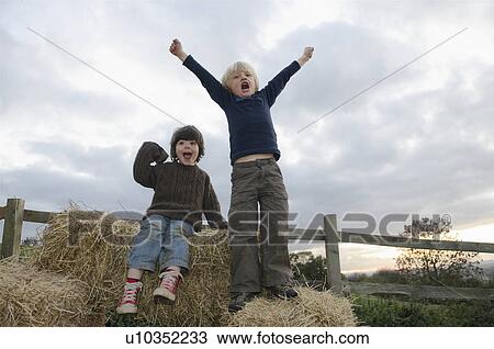 Young boys on hay bales View Large Photo Image Stock Image - Young boys on hay bales. Fotosearch