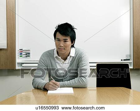 Young business man by desk View Large Photo Image Stock Image - Young business man by desk. Fotosearch