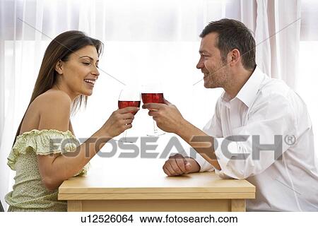Picture - Young couple at home celebrating. Fotosearch