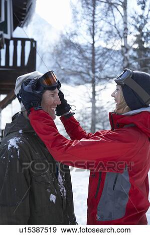 Stock Photo - Young couple in front of chalet. Fotosearch