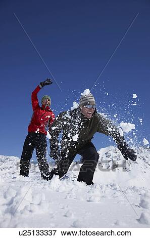 Young couple playing in snow View Large Photo Image Stock Photo - Young couple playing in snow. Fotosearch