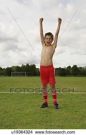 Picture - Young footballer with arms raised. Fotosearch