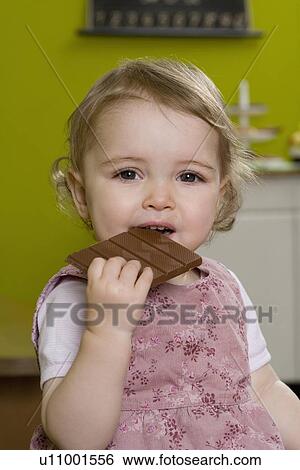 Young girl biting into chocolate bar View Large Photo Image Stock Photograph - Young girl biting into chocolate bar. Fotosearch