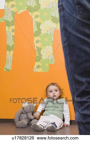 "Young girl on floor, mothers legs aside" View Large Photo Image Stock Photograph - "Young girl on floor, mothers legs aside". Fotosearch