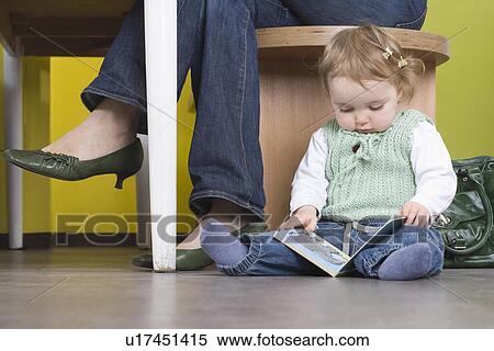 Stock Photography - Young girl on floor with book. Fotosearch