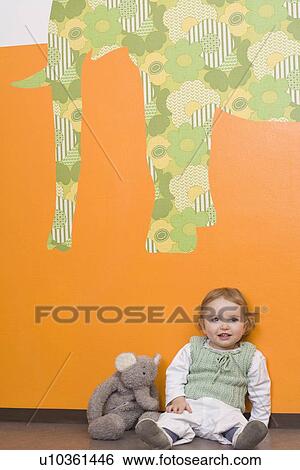 Young girl on floor with elephant View Large Photo Image Stock Photograph - Young girl on floor with elephant. Fotosearch