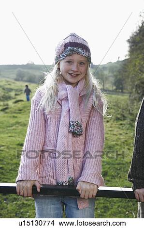 Picture - Young girl on gate in countryside. Fotosearch