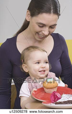 Stock Photo - "Young girl on mothers lap, laughing". Fotosearch