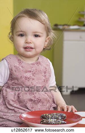 Stock Photo - Young girl on table with sweets. Fotosearch