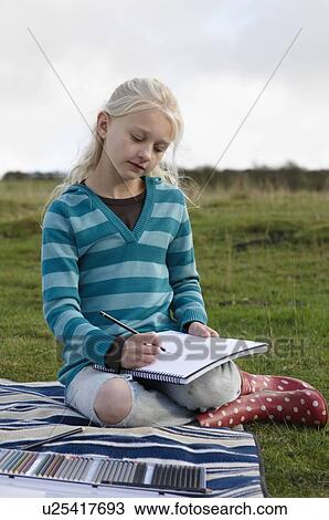 Young girl sketching on hillside View Large Photo Image Stock Image - Young girl sketching on hillside. Fotosearch