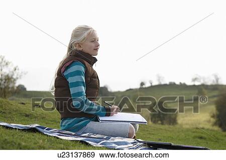Young girl sketching on hillside View Large Photo Image Stock Photo - Young girl sketching on hillside. Fotosearch