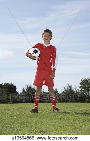 Stock Photograph - Young Male footballer with a ball. Fotosearch