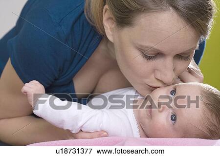 Stock Photo - Young mother kissing her baby. Fotosearch
