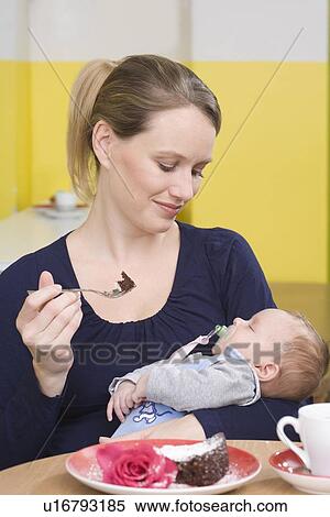"Young mother with baby, eating cake" View Large Photo Image Stock Photography - "Young mother with baby, eating cake". Fotosearch
