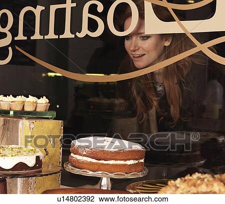 Young woman looking through window View Large Photo Image Stock Image - Young woman looking through window. Fotosearch