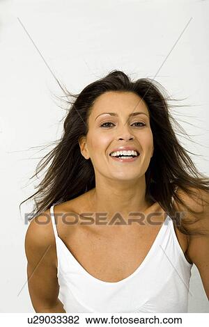 Stock Image - Young woman smiling at camera. Fotosearch