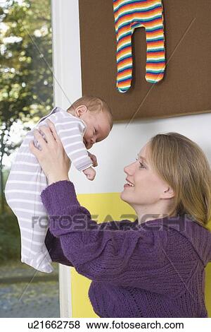 Young woman uplifting her baby View Large Photo Image Stock Photo - Young woman uplifting her baby. Fotosearch