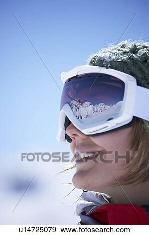 Stock Photo - Young woman wearing ski goggles. Fotosearch
