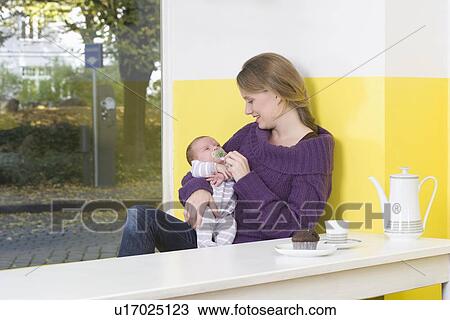 Young woman with baby on table View Large Photo Image Stock Image - Young woman with baby on table. Fotosearch