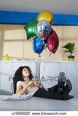 Young woman with balloons in office View Large Photo Image Stock Image - Young woman with balloons in office. Fotosearch