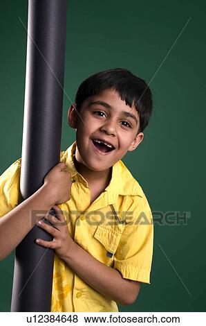 A boy clinging to a pole View Large Photo Image Stock Photo - A boy clinging to a pole. Fotosearch