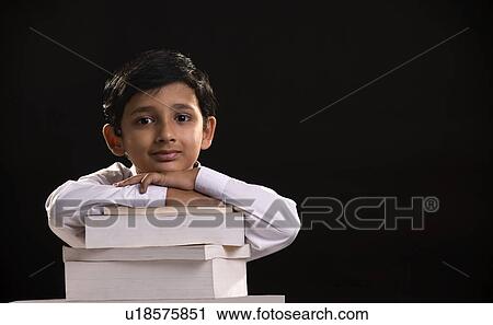 Stock Image - A boy leaning on stack of books. Fotosearch