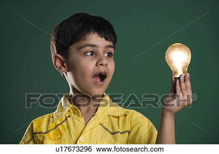 Stock Photograph - A boy looking at a bulb. Fotosearch