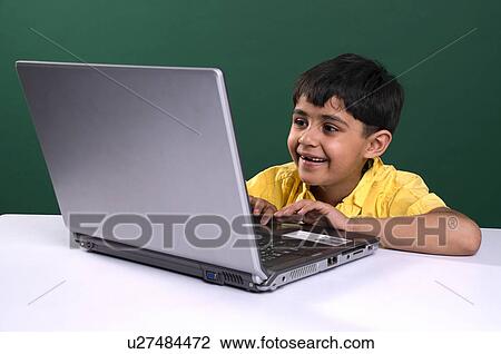 Stock Image - A boy working on a laptop. Fotosearch