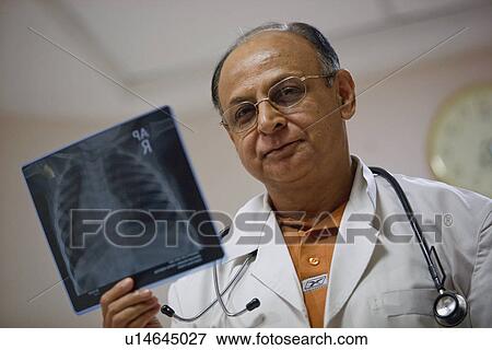 A doctor examining the X-Ray sheet View Large Photo Image Stock Photo - A doctor examining the X-Ray sheet. Fotosearch