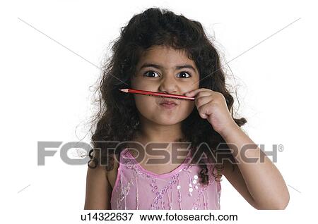A girl places a pencil between her lips and nose View Large Photo Image Stock Photo - A girl places a pencil between her lips and nose. Fotosearch