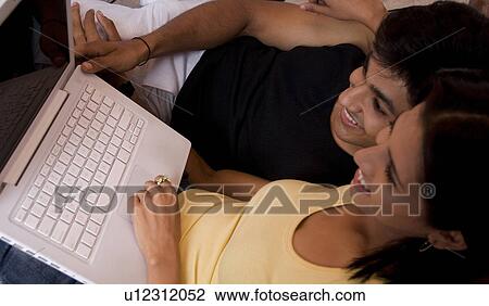 Stock Image - A man and a woman with a laptop. Fotosearch