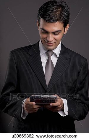 Stock Image - A man holding a communicator. Fotosearch