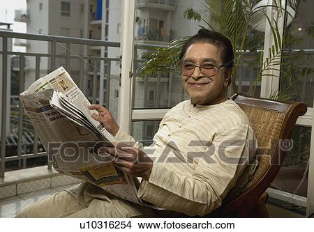 Picture - A man reading the newspaper. Fotosearch
