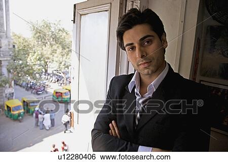 Stock Photograph - A man standing by the window. Fotosearch