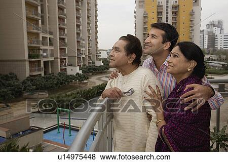 Stock Photo - A man standing with his parents. Fotosearch