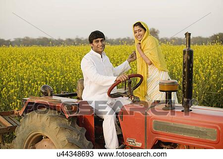 Stock Image - A rural couple on a tractor. Fotosearch