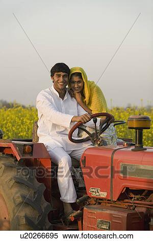 Stock Photography - A rural couple on a tractor. Fotosearch