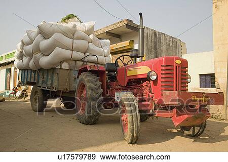 Stock Photo - A tractor with a trailer filled with sac. Fotosearch