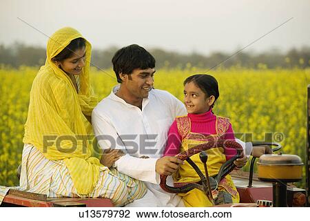 Stock Image - A typical rural family on a tractor. Fotosearch